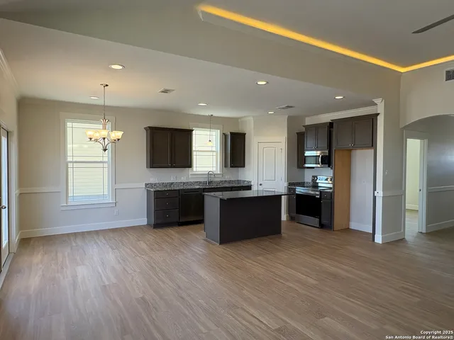 a large kitchen with a large counter top stainless steel appliances and a window
