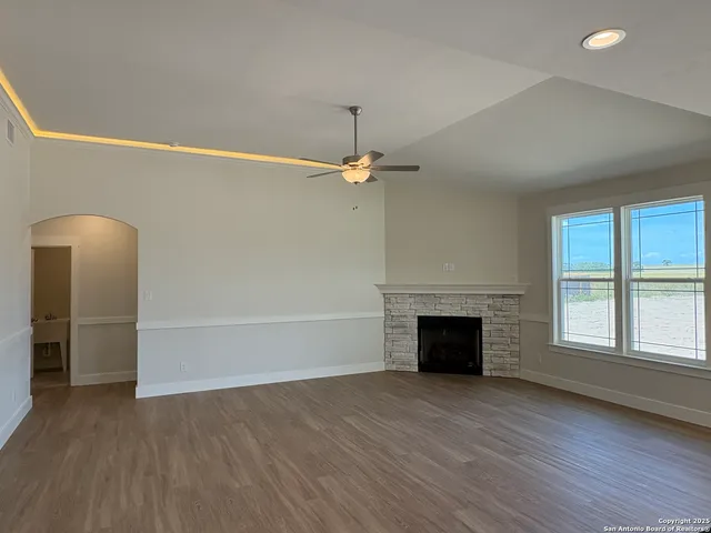 an empty room with windows and fireplace