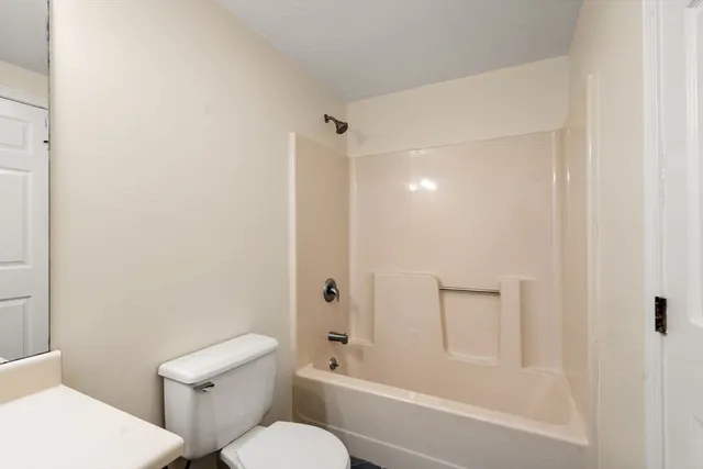 a bathroom with a granite countertop toilet a sink and shower
