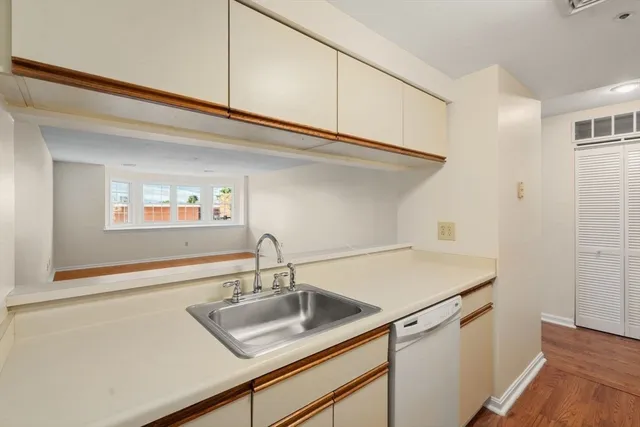 a kitchen with a sink cabinets and a wooden floor