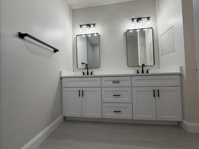 a bathroom with double sink and mirror