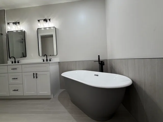 a bathroom with a double vanity sink and a mirror