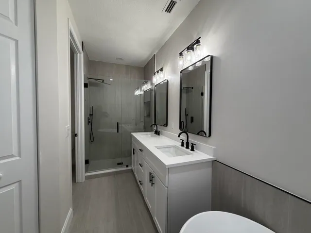 a bathroom with a sink vanity mirror and toilet