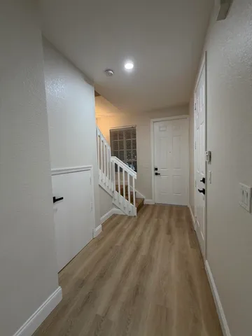a view of a hallway with wooden floor and entryway