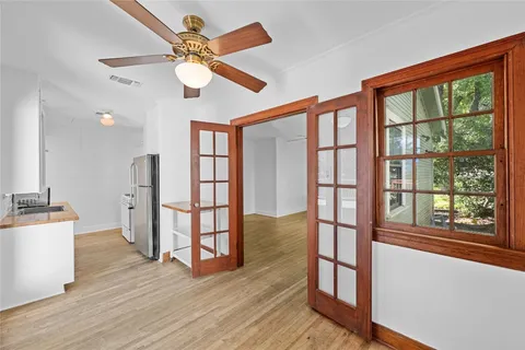 a view of empty room with wooden floor and fan