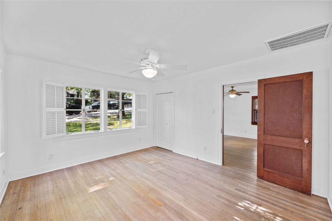 516 Lockhart Drive Austin, TX 78704 - Photo 13 of 25 an empty room with wooden floor cabinet and windows