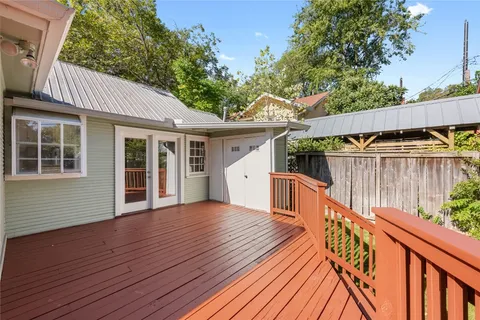 a view of a house with wooden deck and furniture