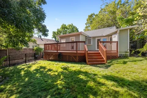 a view of a house with a yard and deck