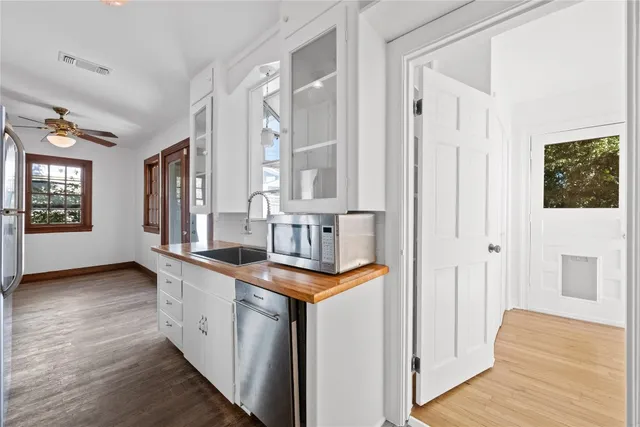 a kitchen with stainless steel appliances granite countertop a sink and a wooden floor