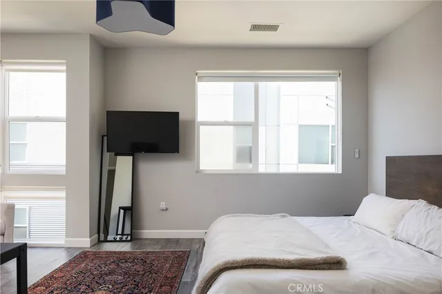 a bedroom with a bed tv and a window