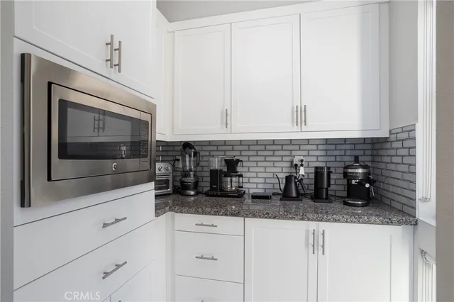 a kitchen with white cabinets and white appliances