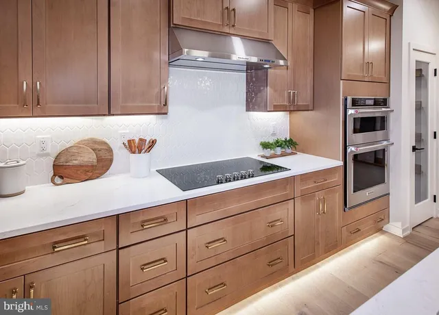 a kitchen with stainless steel appliances granite countertop a sink a stove and cabinets
