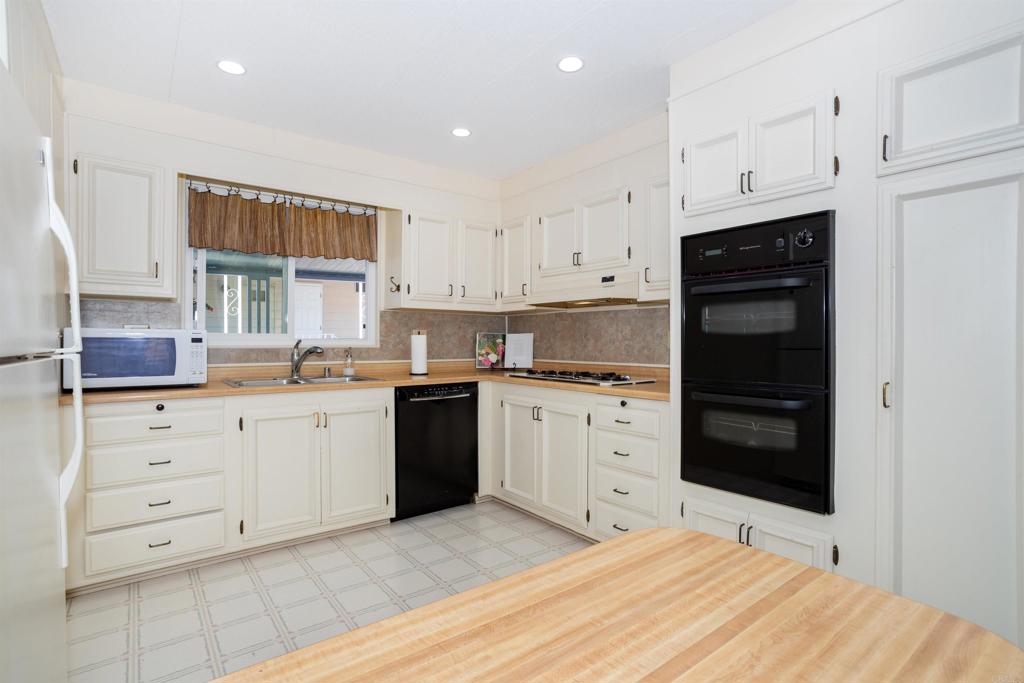 650 South Rancho Santa Fe Road, Unit 54 San Marcos, CA 92078 - Photo 4 of 21 Newer recessed lighting, dishwasher, oven, disposal, faucet and sink.