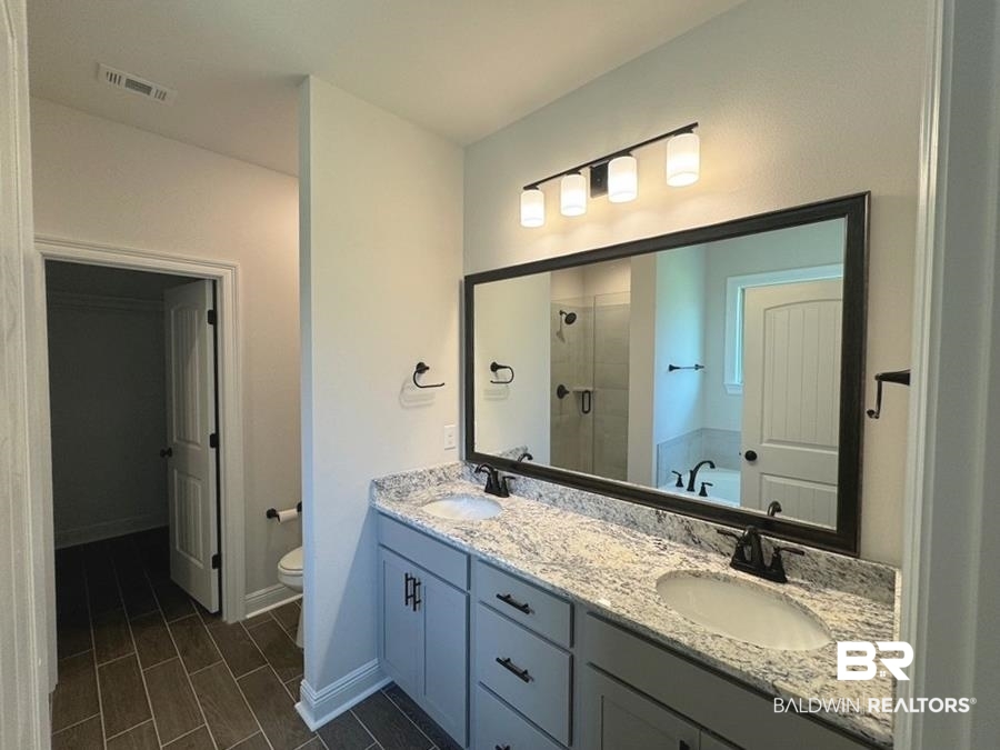 844 Sumter Loop Foley, AL 36535 - Photo 8 of 18 Full bathroom with dual vanity, tile patterned floors, toilet, and separate shower and tub
