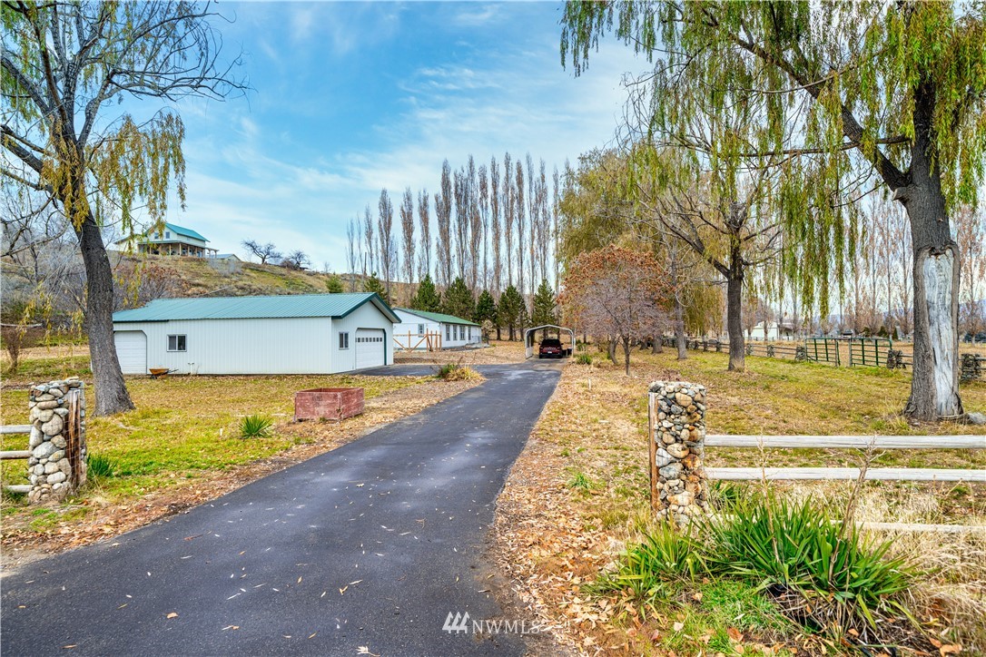 25 Caudill Road Omak, WA 98841 - Photo 1 of 40 a view of a swimming pool with a lawn chairs under an umbrella