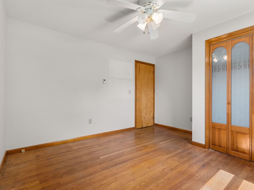 16 May Road Ludlow, MA 01056 - Photo 13 of 28 an empty room with wooden floor fan and windows