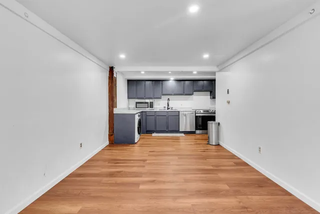 a kitchen with stainless steel appliances granite countertop a sink a stove top oven a counter space and cabinets