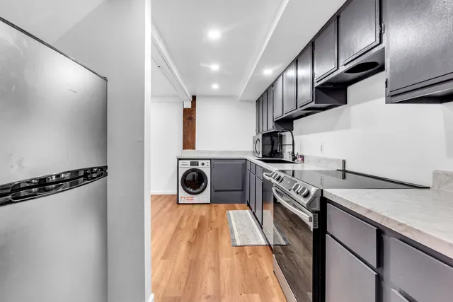 a kitchen with kitchen island granite countertop wooden cabinets and a stove