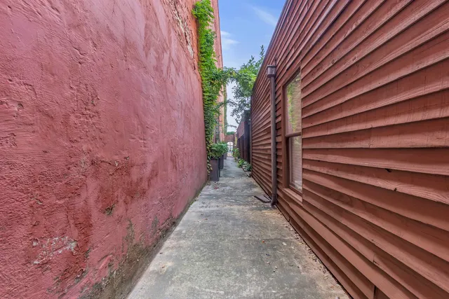 a front view of a building with a yard and plants