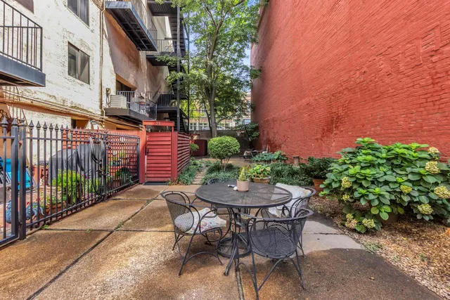 a patio with table and chairs and potted plants