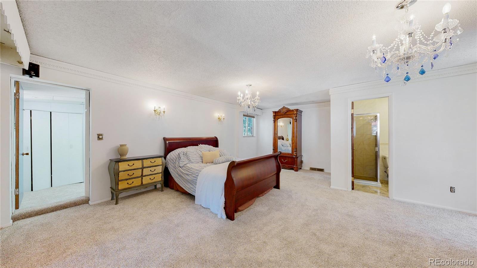 4169 Hooker Street Denver, CO 80211 - Photo 22 of 48 a spacious bedroom with a bed and a chandelier