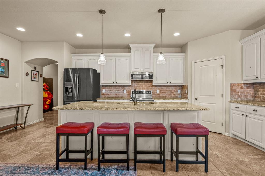 108 Bosque Court Azle, TX 76020 - Photo 8 of 33 a kitchen with kitchen island a table and chairs in it