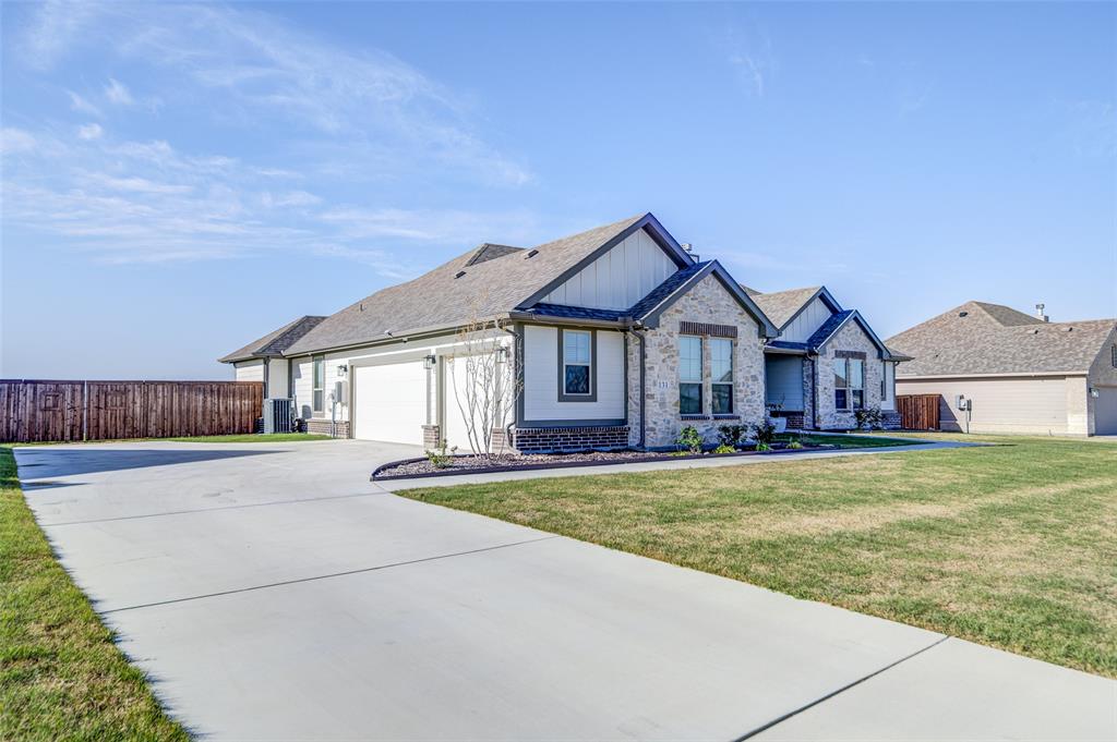 131 Clear Crk Lane Rhome, TX 76078 - Photo 25 of 29 View of front of home with stone siding, concrete driveway, board and batten siding, and an attached garage