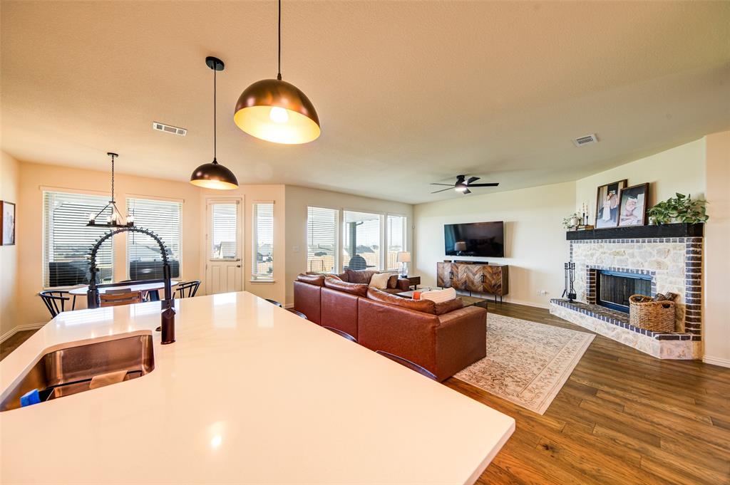 131 Clear Crk Lane Rhome, TX 76078 - Photo 3 of 29 Living room with dark wood-type flooring, a brick fireplace, and a ceiling fan