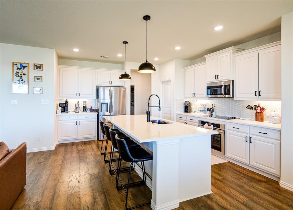 131 Clear Crk Lane Rhome, TX 76078 - Photo 7 of 29 Kitchen with white cabinets, dark wood-type flooring, and a kitchen breakfast bar