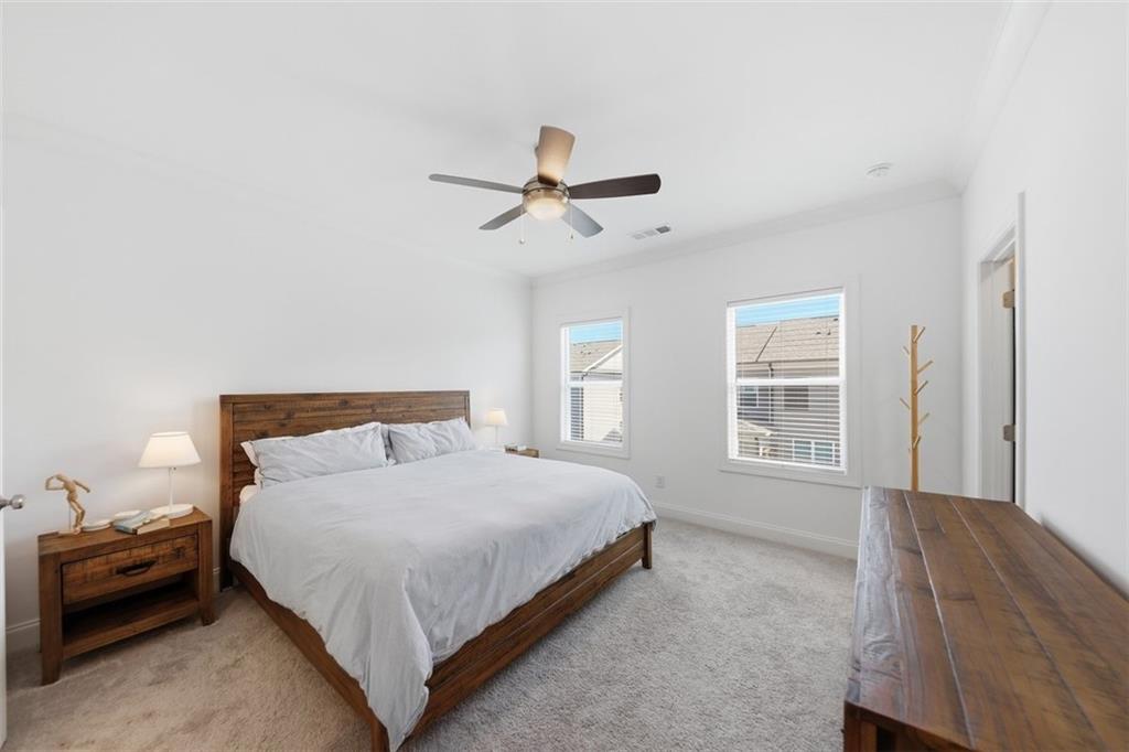 3193 Bartee Walk Suwanee, GA 30024 - Photo 14 of 27 a bedroom with a bed chandelier and a window
