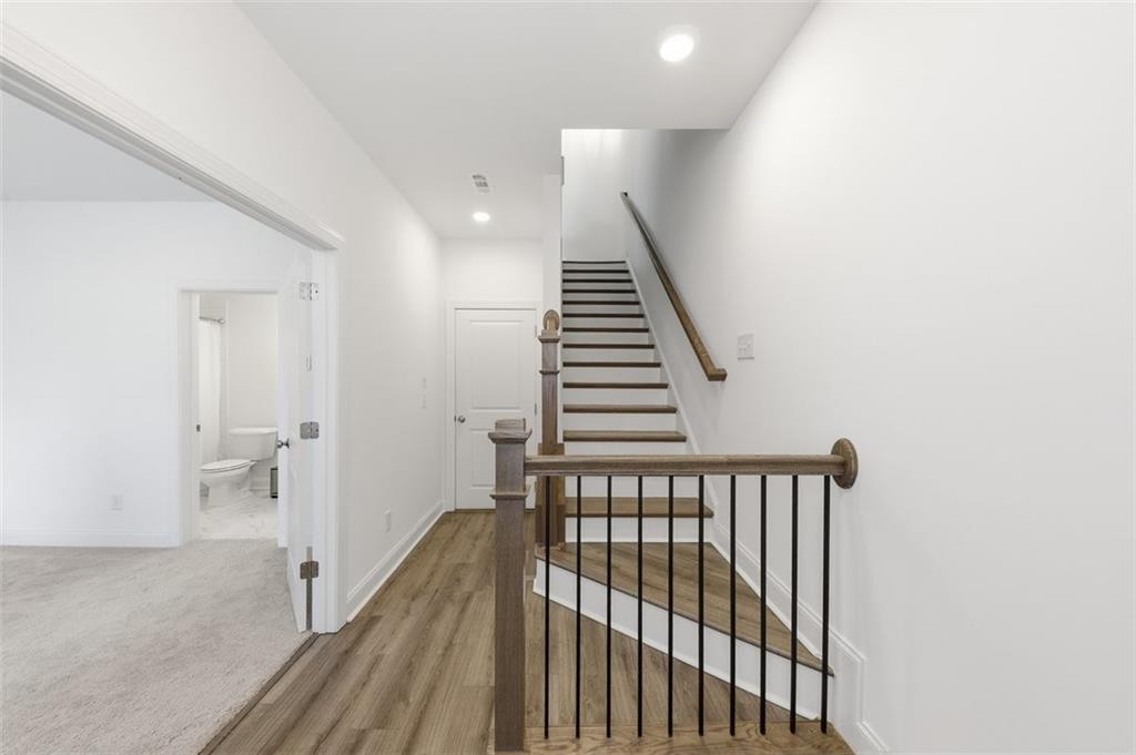 3193 Bartee Walk Suwanee, GA 30024 - Photo 2 of 27 a view of a hallway with wooden floor and stairs