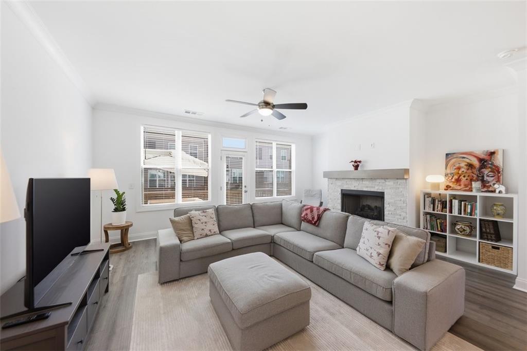 3193 Bartee Walk Suwanee, GA 30024 - Photo 5 of 27 a living room with furniture a fireplace and a flat screen tv