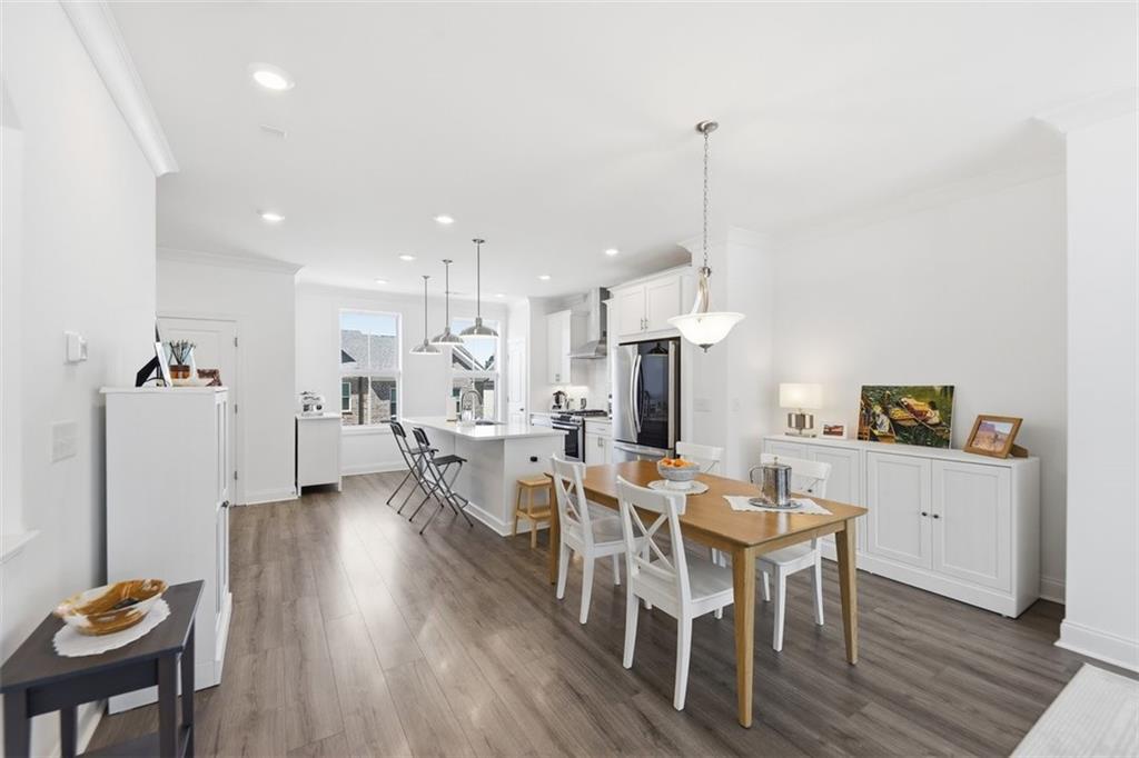 3193 Bartee Walk Suwanee, GA 30024 - Photo 7 of 27 a view of a dining room with furniture and wooden floor