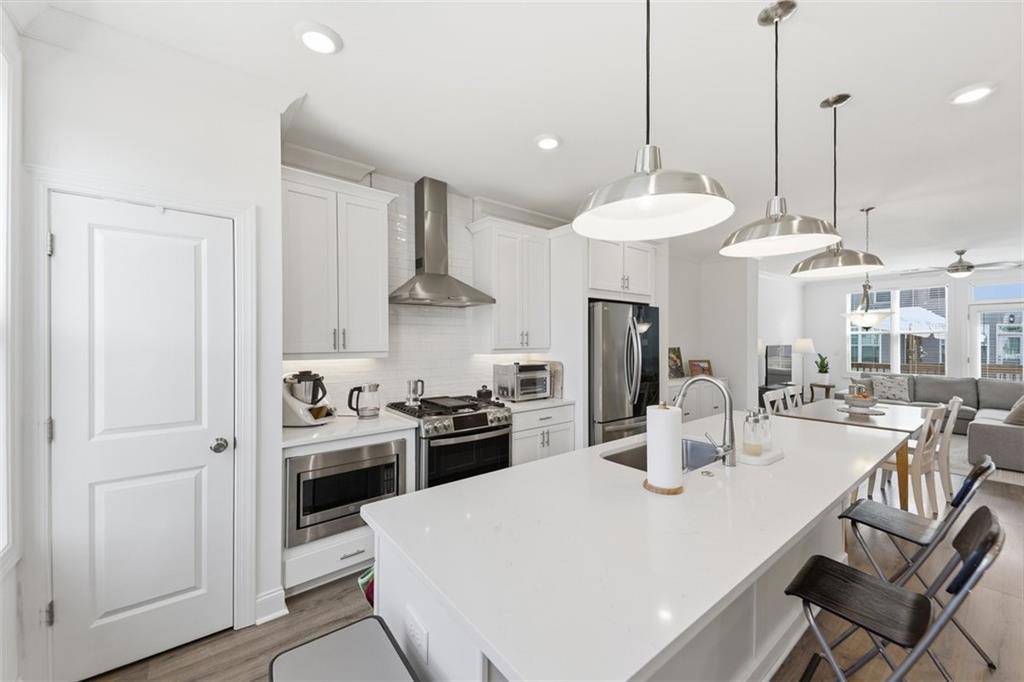 3193 Bartee Walk Suwanee, GA 30024 - Photo 10 of 27 a kitchen with stainless steel appliances granite countertop a sink a stove a refrigerator and island