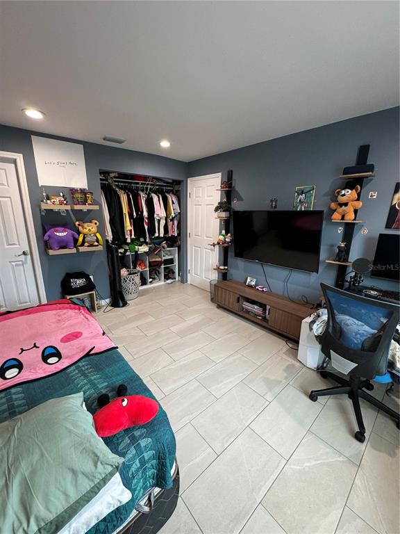 7102 Reindeer Road Tampa, FL 33619 - Photo 16 of 25 a bedroom with furniture and a flat screen tv