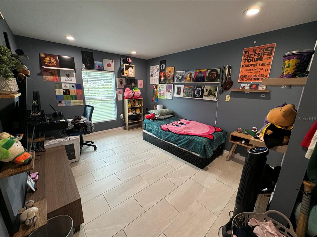 7102 Reindeer Road Tampa, FL 33619 - Photo 18 of 25 a bedroom with furniture and a flat screen tv