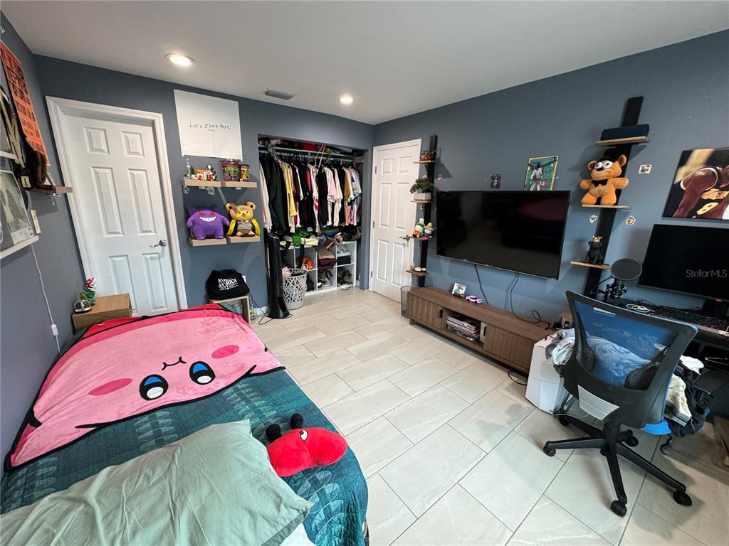 7102 Reindeer Road Tampa, FL 33619 - Photo 19 of 25 a bedroom with furniture and a flat screen tv