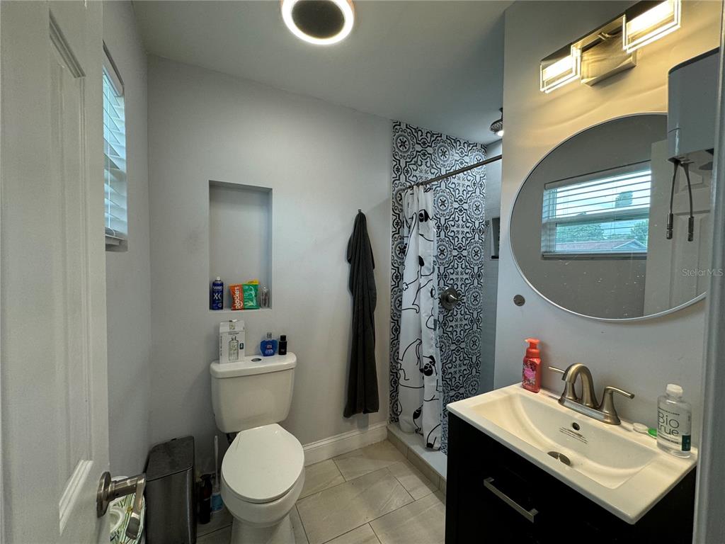7102 Reindeer Road Tampa, FL 33619 - Photo 20 of 25 a bathroom with a sink toilet and a mirror
