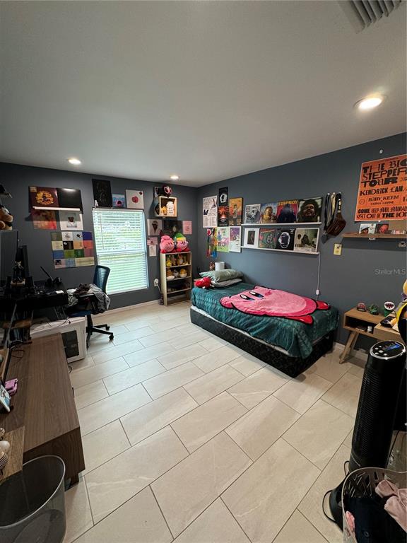 7102 Reindeer Road Tampa, FL 33619 - Photo 21 of 25 a room with gym equipment and a flat screen tv