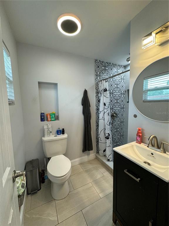 7102 Reindeer Road Tampa, FL 33619 - Photo 23 of 25 a bathroom with a toilet sink and shower