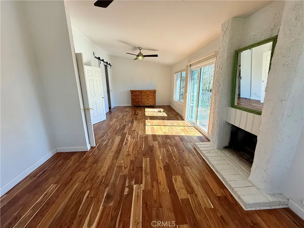 a living room with hard wood floors and a bed