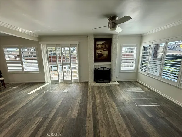 a view of empty room with a fireplace and wooden floor