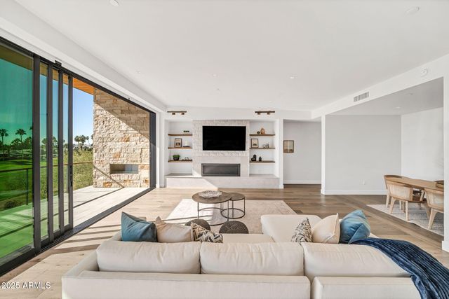 a spacious bedroom with a bed painting on the wall and a large window