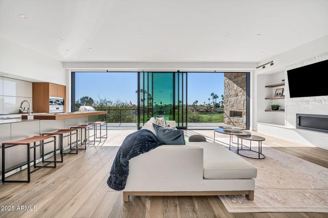 a kitchen with stainless steel appliances granite countertop a refrigerator a sink dishwasher and a stove with wooden floor