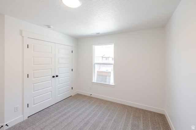 5224 South Acacia Drive, Unit 809 Mapleton, UT 84664 - Photo 18 of 23 Bedroom featuring neutral-toned carpet, a single window, and bi-fold closet doors with black hardware