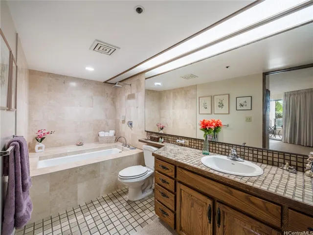 a bathroom with a granite countertop sink mirror and a bathtub