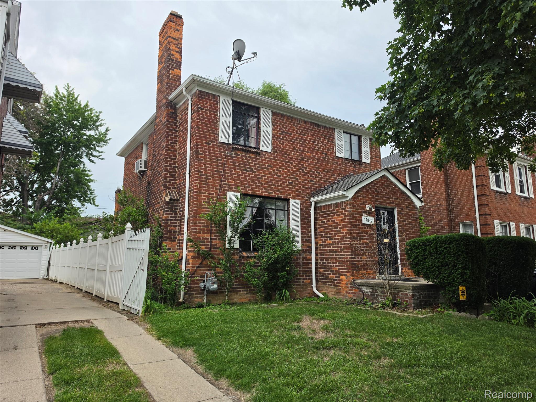 15832 Griggs Street Detroit, MI 48238 - Photo 1 of 24 Brick exterior residence featuring a prominent chimney, a covered front entry, and white window shutters