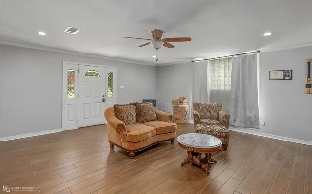 a living room with furniture and a wooden floor