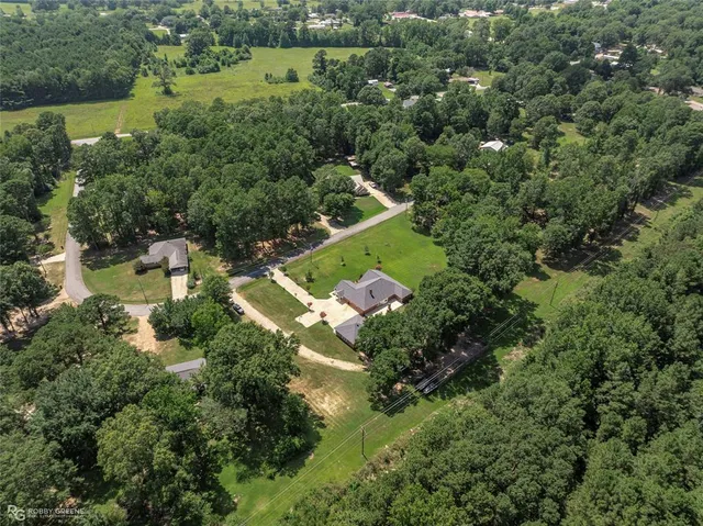 an aerial view of a house with a yard and lake view