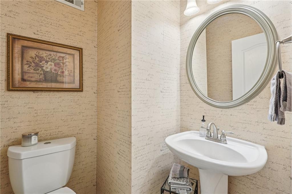 3820 Ridge Point Drive Suwanee, GA 30024 - Photo 23 of 41 a bathroom with a toilet a sink and a mirror
